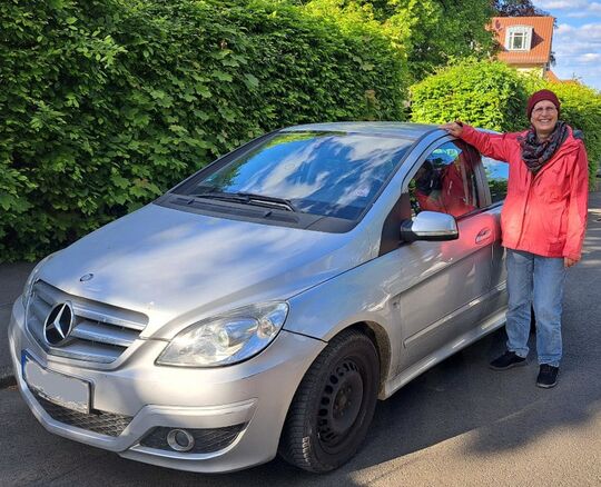 Ein alter Mercedes, der seinen Dienst getan hat, mit seiner Fahrerin
